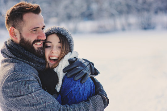 Happy Loving Couple Walking In Snowy Winter Forest, Spending Christmas Vacation Together. Outdoor Seasonal Activities. Lifestyle Capture.