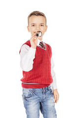 Portrait elegant young handsome joyful little kid singing on a b