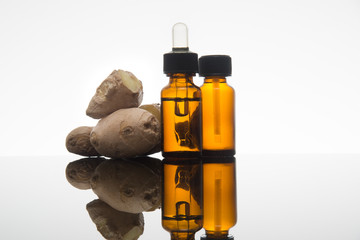 Ginger essential oil in amber bottle with ginger root and dropper - 101030472
