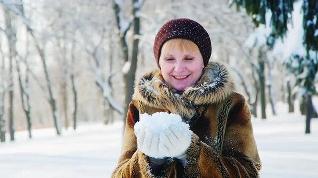 Winter fun - woman throws snow