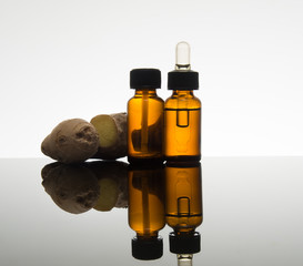 Ginger essential oil in amber bottle with ginger root and dropper