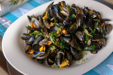 Boiled mussels in a cooking dish on a on table. Selective focus