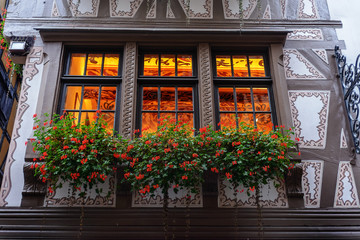 Fototapeta na wymiar A flower bed of flowers on the window facade of the old house in europe . France