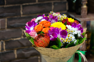 Flowers bouquet with Leucospermum, roses and orchids.