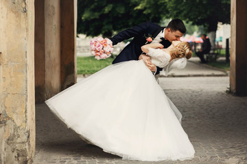 Happy handsome groom and blonde beautiful bride in white dress k