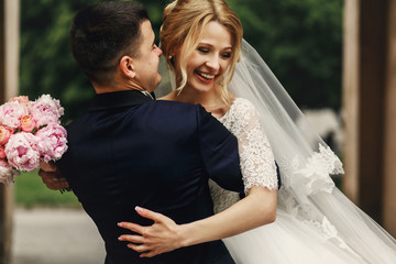 Happy handsome groom and blonde beautiful bride in white dress h