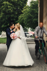 Happy handsome groom and blonde beautiful bride in white dress k