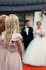 Two beautiful elegant bridesmaids in pink dresses looking at mar