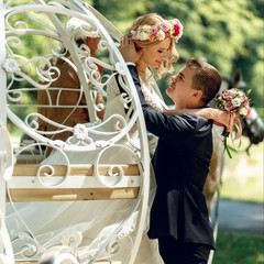 Romantic fairy-tale wedding couple bride and groom kissing in ma