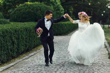 Happy wedding couple charming groom and blonde bride dancing in