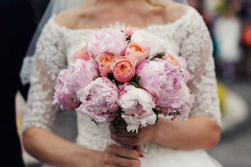 Elegant stylish bride in  vintage wedding dress with rose bouque