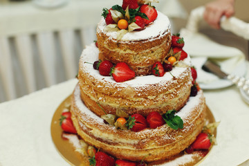 Delicious and tasty wedding cake with coconut strawberries and c