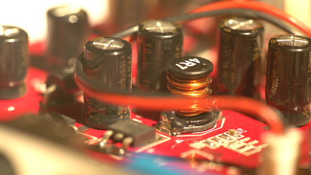 A side of a red textolite circuit board with various electronic components