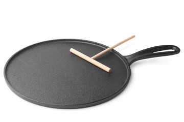 Cast iron pan for baking pancakes with timber spatula