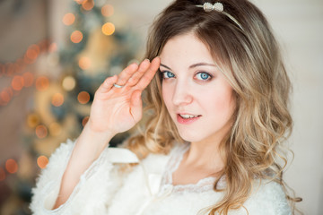 Fototapeta premium girl near the decorated Christmas tree in beautiful light interior