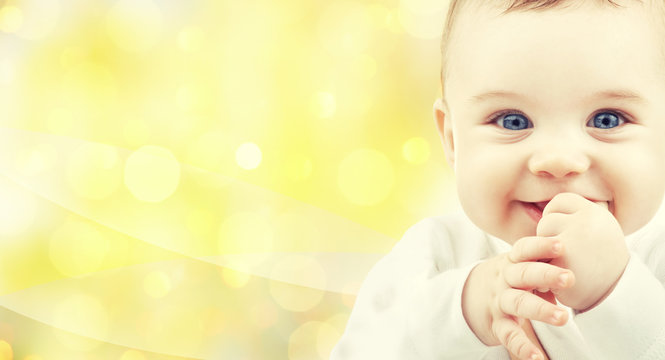 close up of happy baby over yellow background
