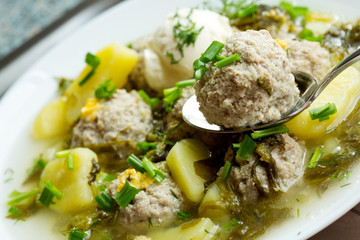 Sorrel soup with meatballs .