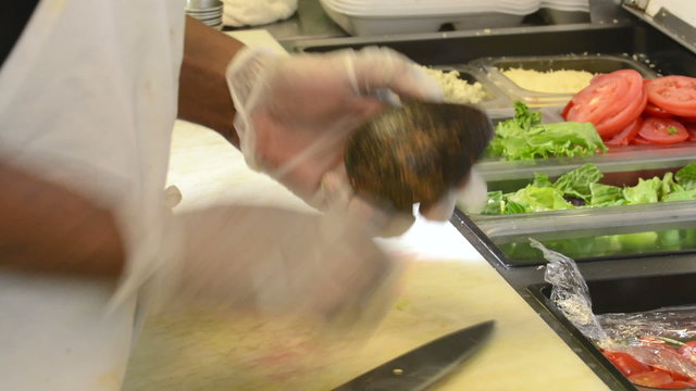 A chef slicing an avocado in a commercial kitchen
