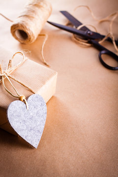 Valentines day gift wrapping with boxes and scissors over paper or wooden background.