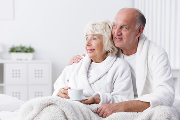 Happy retired couple in bed