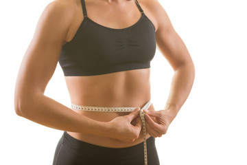 Woman with perfectly shaped upper body measuring up her waist