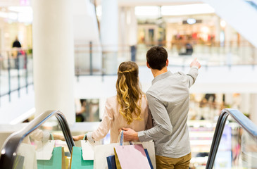 happy young couple with shopping bags in mall