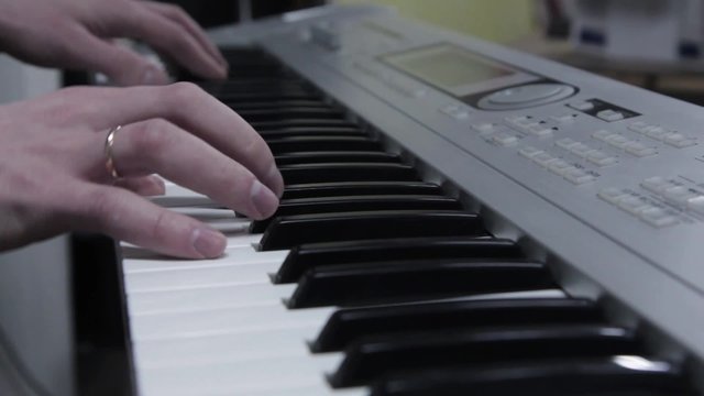 Hands of the musician playing on a synthesizer