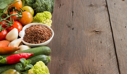Uncooked Red rice in a bowl with vegetables