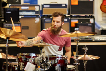 male musician playing cymbals at music store