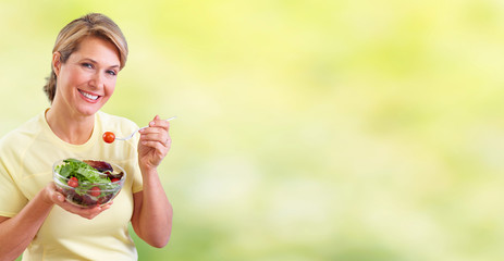 Elderly woman eating salad.