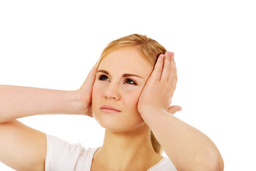 Fototapeta premium Young woman with headache holding her hand to the head