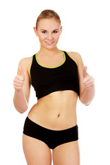 Fototapeta na wymiar Young athletic woman showing thumbs up