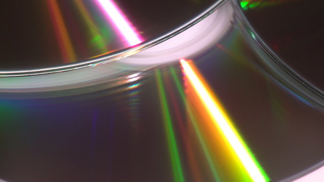 A yellow glowing light reflection effect on compact disks