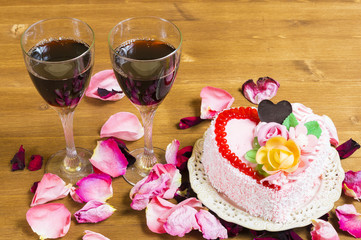 Heart-shaped cake and wine in glasses
