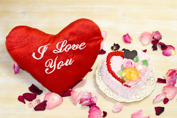 Tort w kształcie serca i czerwone serce z napiem"I Love You" na drewnianym tle © Mike Mareen