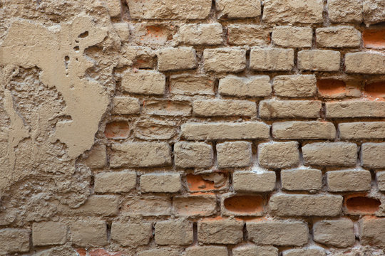 Old brick ochre painted wall. Background texture