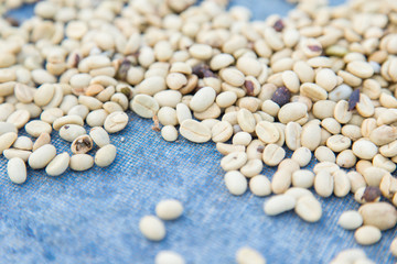 un-roasted coffee beans heap with shallow depth of field