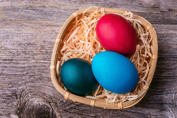 Fototapeta na wymiar Easter eggs in basket on wooden background.