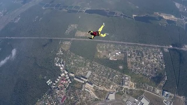 Skydiver rotation above the land during accelerated free fall course. Slow motion