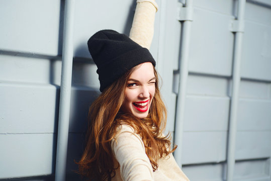 Portrait of a beautiful brunette girl outdoors in hat, lifestyle