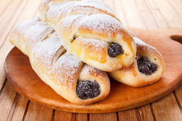 Homemade pastries with poppy seeds on a wooden background