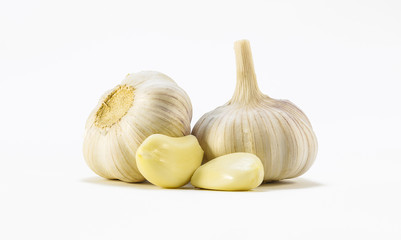 The two heads of garlic, and two slices on a white background