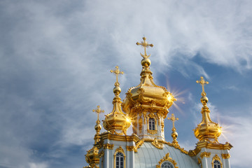 Fototapeta na wymiar Orthodox church with gold dome on blue cloudy sky