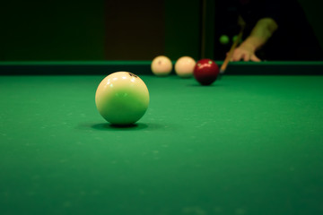 Man playing in pool billiards on green table