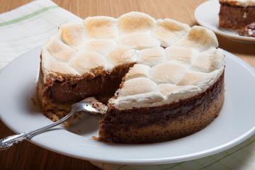 Sweet cake with chocolate on a light wooden table. Selective foc