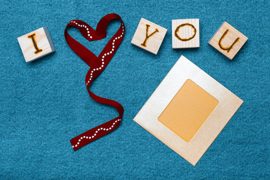 Ribbon heart, love inscription on wooden cubes, photo frame and