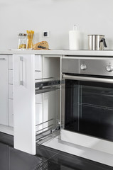 Fototapeta premium Part of modern kitchen with electric stove oven details, drawers