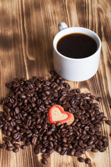 Coffee beans and coffee in white cup on wooden table for backgro