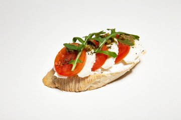 Sandwich with mozzarella, tomato and arugula on white background