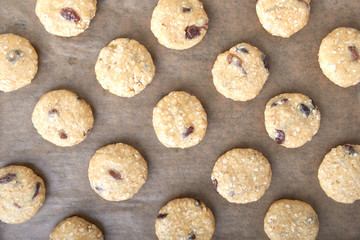 Uncooked oatmeal cookies on baking paper